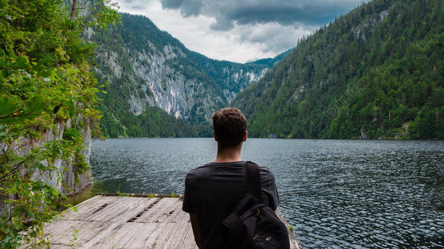 自然壮丽群山和湖水背包男子山水自然旅游背景图片