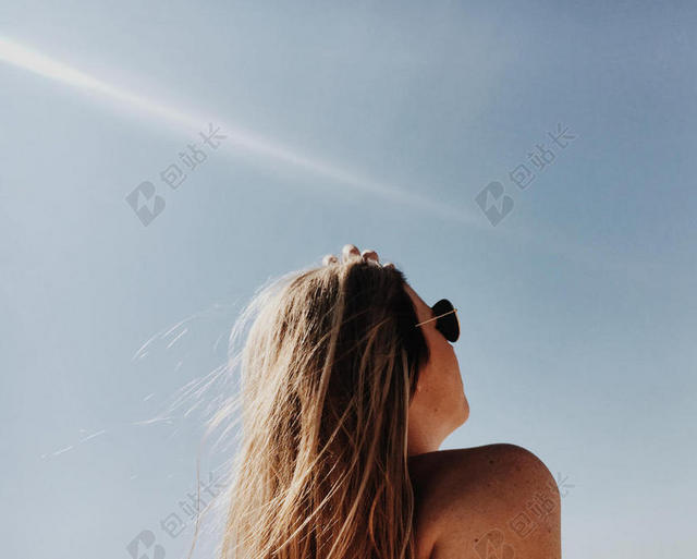 蓝天下戴墨镜的女人背景图片