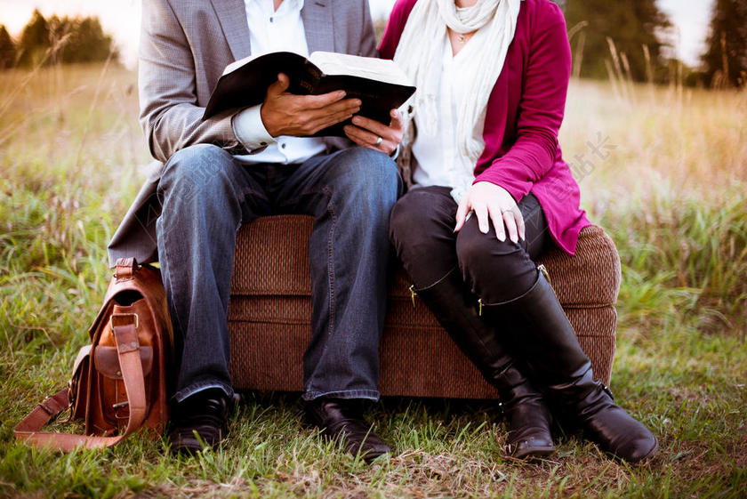 人温馨旅行箱上看书的男女背景图片