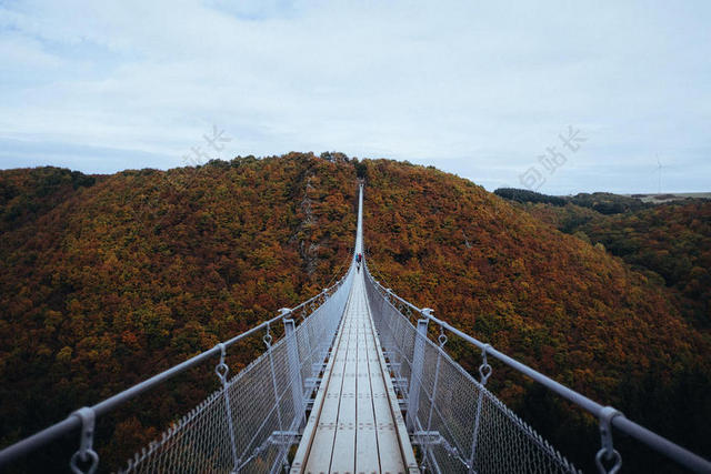 山峰间的白色吊桥背景图片