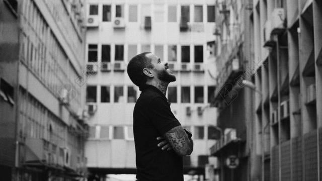 黑灰人物亲和建筑物下的男子笑容摄影背景图片