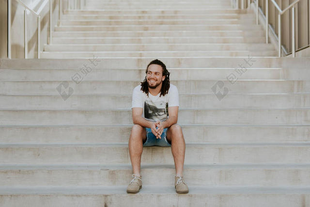 白色阶梯上坐的男人背景图片