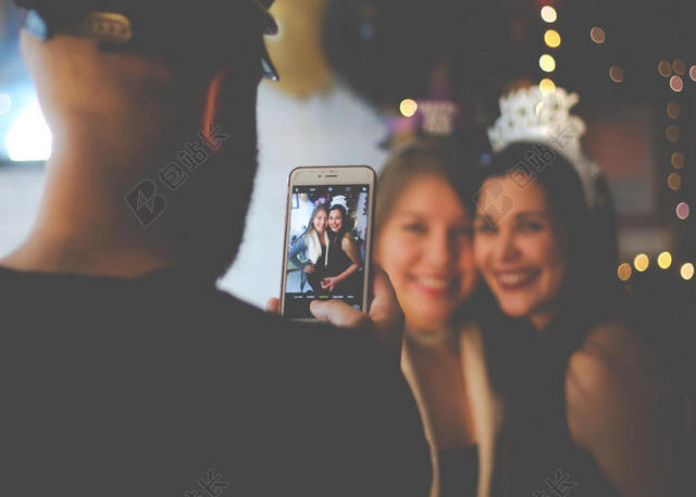 人物美丽男子在帮女孩们拍照室内庆祝人物摄影背景图片