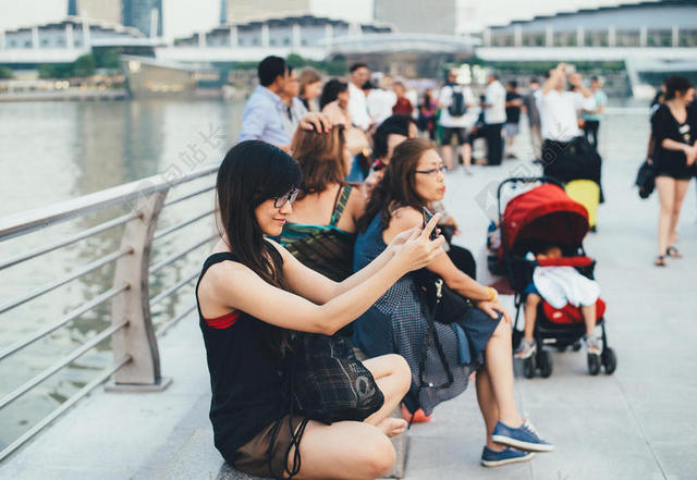 岸边拍照的游客背景图片