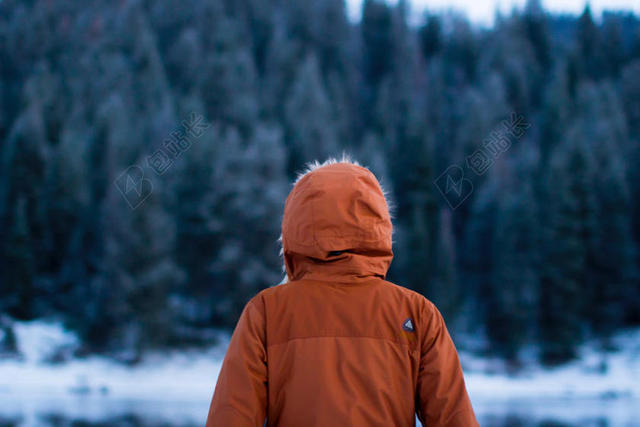 橙灰人物鲜明户外积雪树林边的人雪景人物户外背景图片