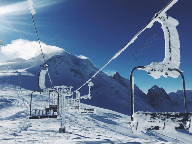 蓝白蓝天下的雪山和缆车自然雪景背景图片