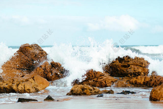 黄色的礁石和白色的海浪背景图片