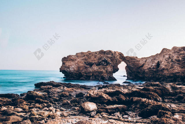 棕蓝自然蓝天下海滩边的岩石景点旅游大海自然背景图片