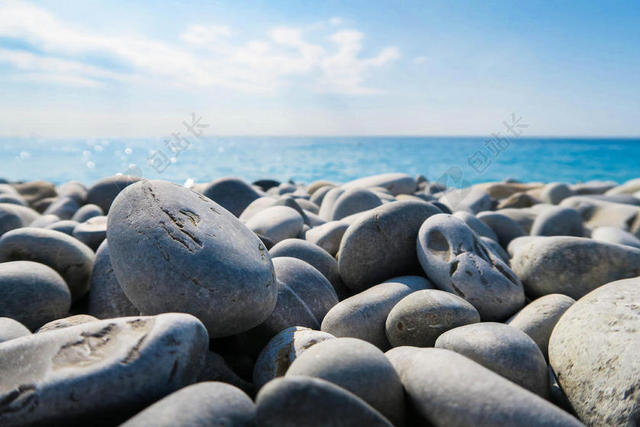 灰蓝大海美丽蓝天下海边的石子大海自然景点背景图片