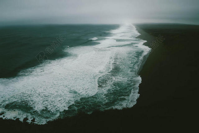 白色的海浪和黑色的海滩背景图片
