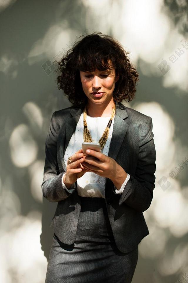 玩手机的商务女人背景图片