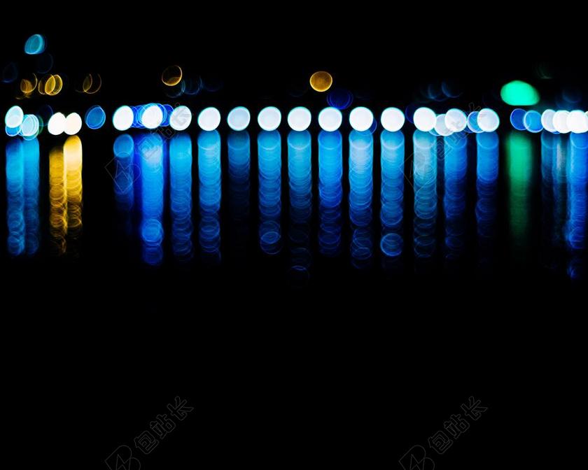 夜晚海面上的彩色灯光背景图片