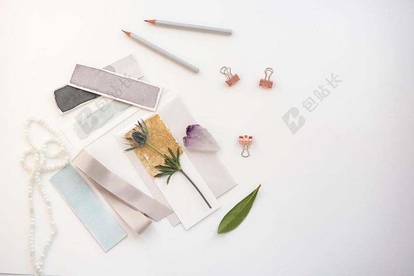 白色桌子上的绿叶和贺卡背景图片