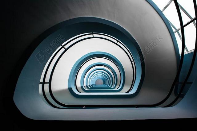 昏暗的白色回旋楼梯背景图片