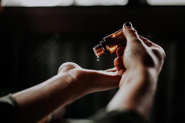 黄黑手势简单拿着瓶子滴在手上手势健康背景图片
