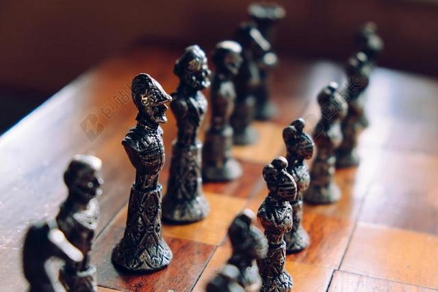 棕色棋盘上黑色的棋子背景图片