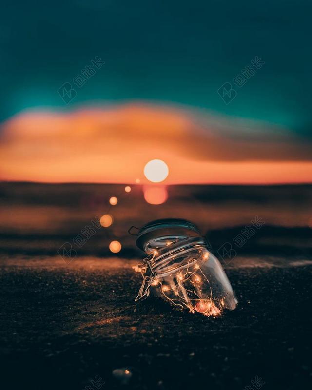 清晨的太阳和沙滩上的玻璃罐子背景图片