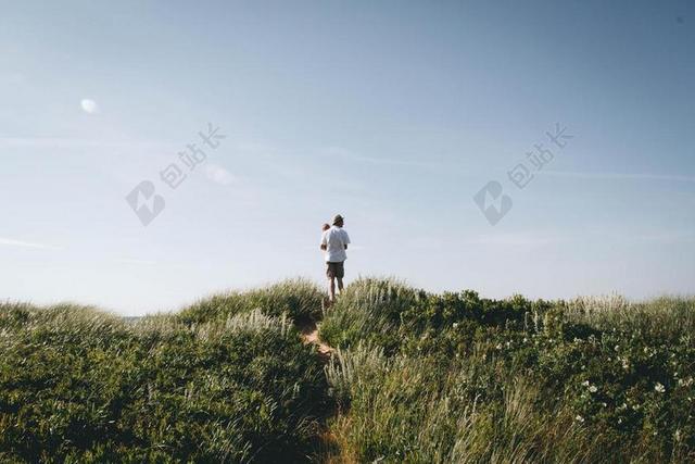 蓝绿任务温馨蓝天下草地上的大人和小孩亲子家人户外自然背景图片