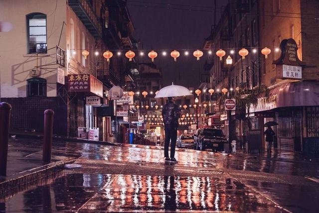 夜晚街头的青年和彩灯背景图片