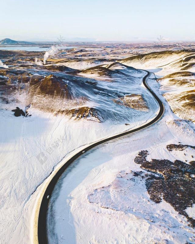 冬天雪地里的黑色公路背景图片
