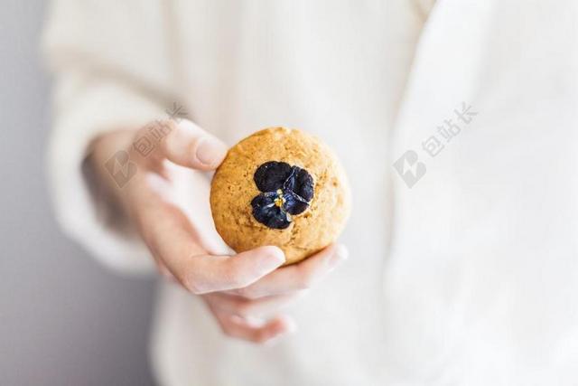 女人手中的蓝莓饼干背景图片