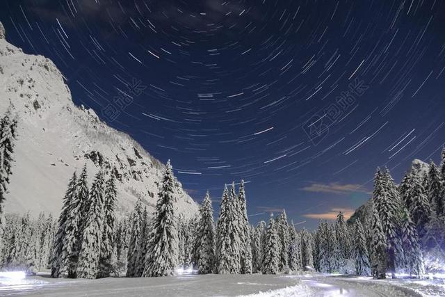 白色的雪林和旋转的星空背景图片