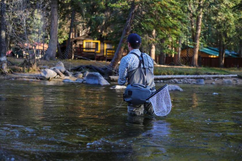 休闲捕鱼清新人站水中捕鱼户外背景图片