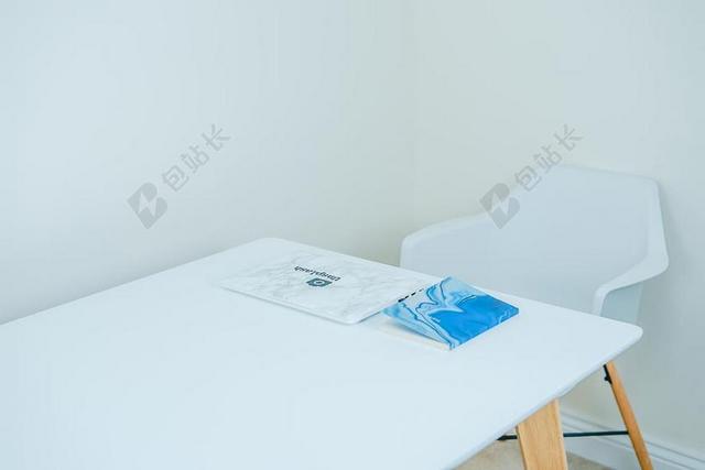 白色的桌椅和彩色的本子背景图片