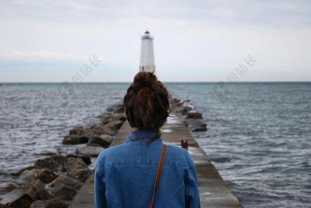 海中白色的灯塔和男人背景图片
