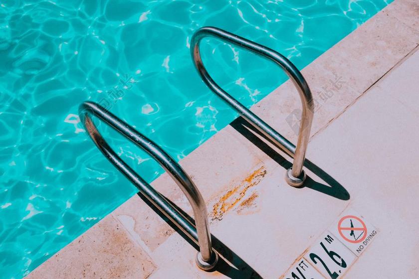 蓝色的泳池和金属扶手背景图片