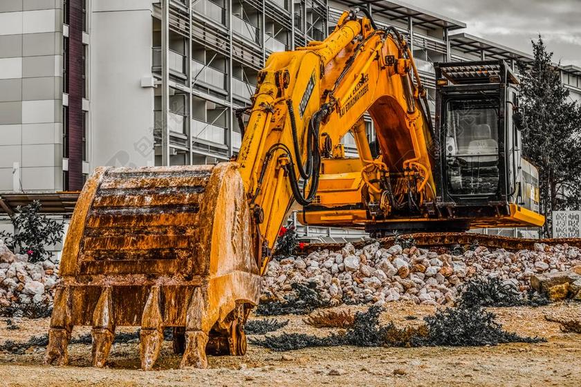 废墟上的黄色的挖掘机背景图片