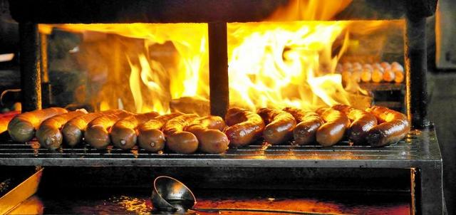享用BRATWURST 烤架 烧烤 香肠 烟 腌制的肉类 食品