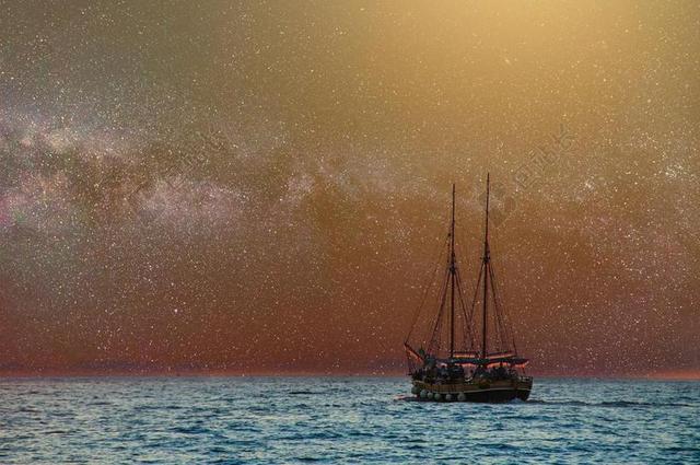 海面的帆船和星空背景图片