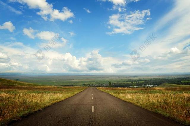 草原上黑色的公路背景图片
