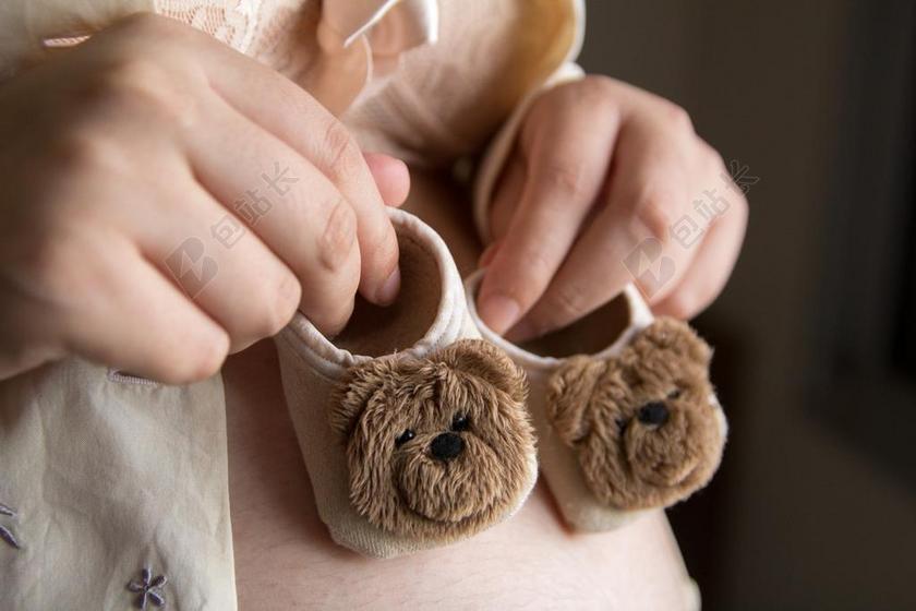 怀孕的女人和婴儿的鞋子背景图片