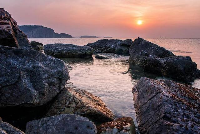 石头海滩日落岛屿旅行背景图片