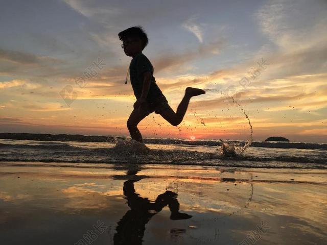 旅游自然夕阳下岸边奔跑的小孩背景图片